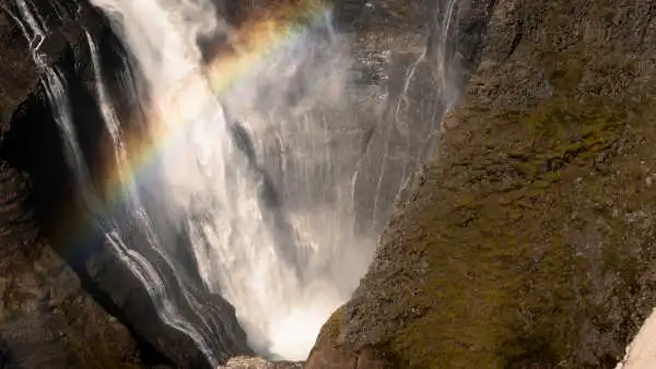 CloseUp of the tip of a waterfall with a rainbow over it